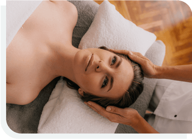 A woman laying on top of a bed with her hands above her head.